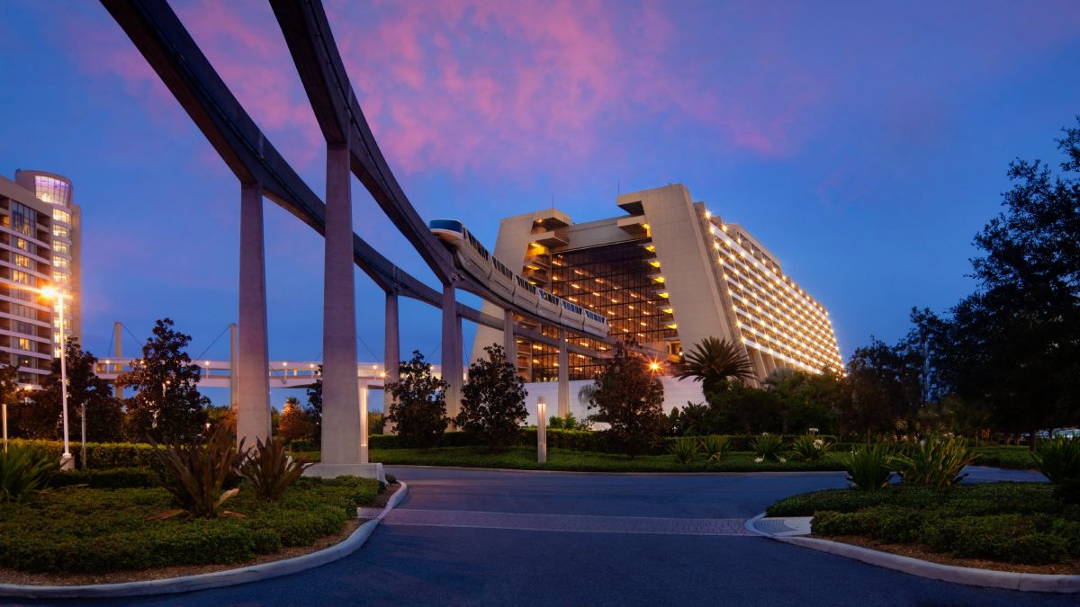 Disney's Contemporary Resort at dusk with the Walt Disney World monorail passing through, connecting guests to Magic Kingdom Park and EPCOT.