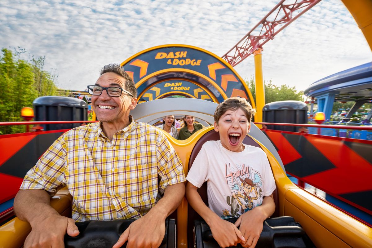 A father and son riding Slinky Dog Dash in Toy Story Land at Disney's Hollywood Studios, Walt Disney World Resort.