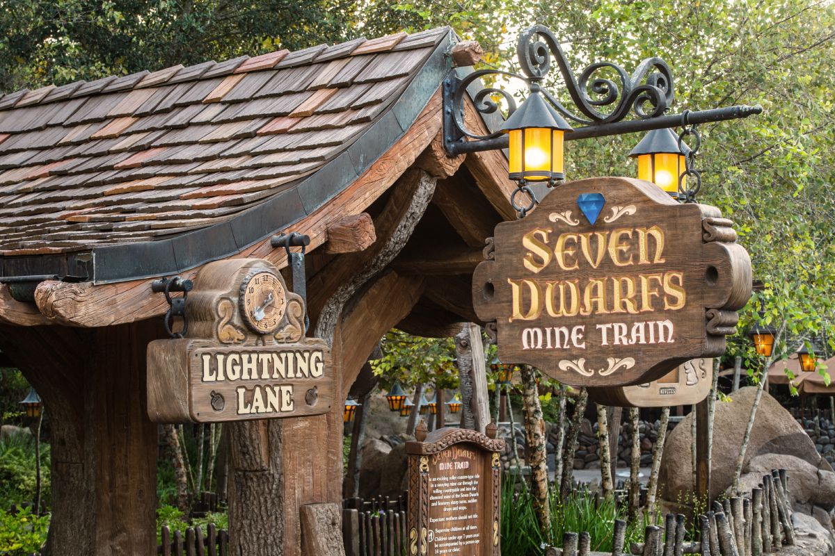 The themed Lightning Lane entrance sign at Seven Dwarfs Mine Train in Magic Kingdom, one of the most popular Lightning Lane Single Pass attractions at Walt Disney World.
